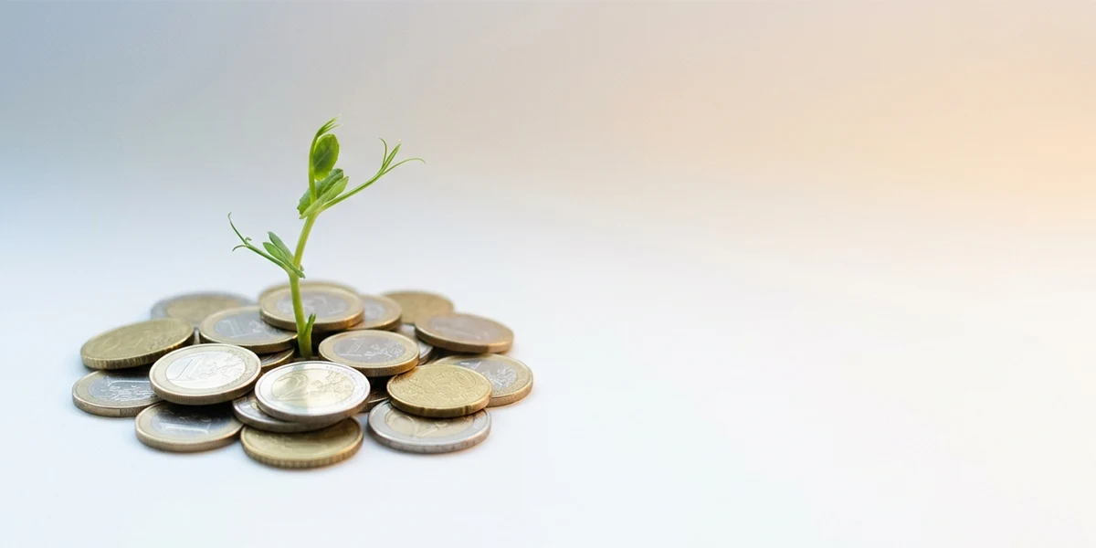 Planta brotando de un montón de monedas de euro, simbolizando el crecimiento del ahorro en un depósito bancario