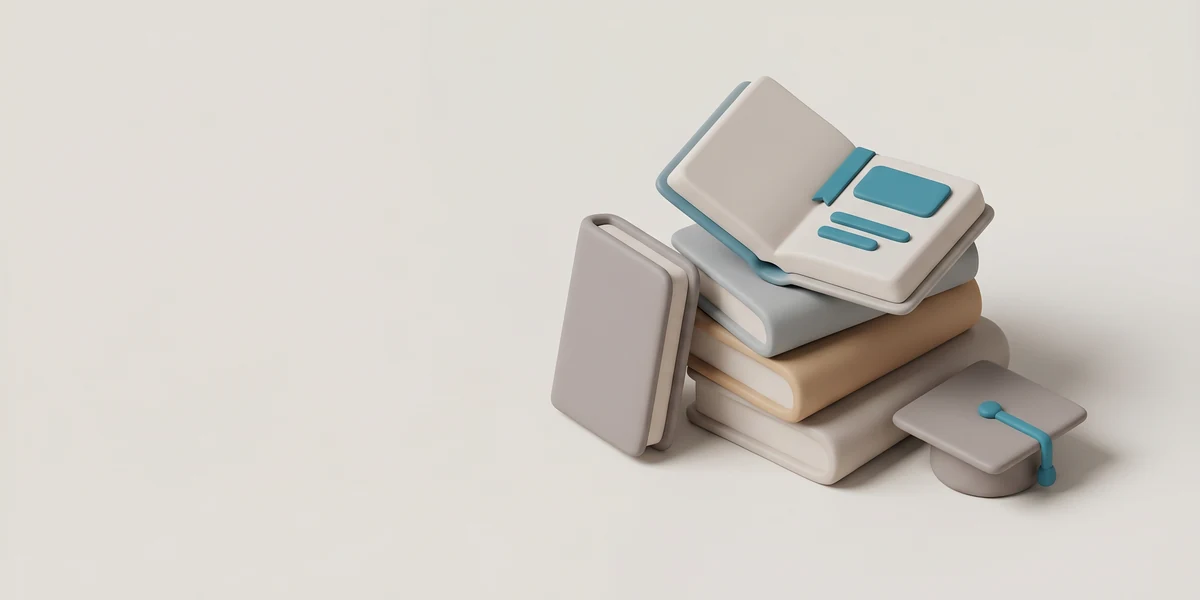 Pila de libros junto a un birrete de graduación, libros de educación financiera